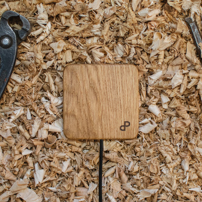 Handcrafted wooden wireless charger on wood shavings, showcasing elegant design and eco-friendly materials.